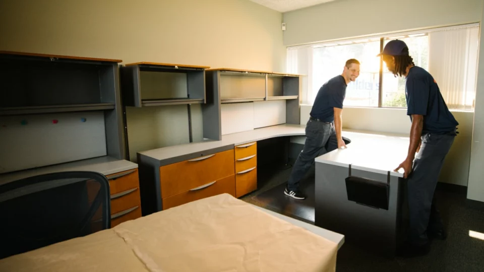 Démontage et protection du mobilier dans un bureau en cours de vidage