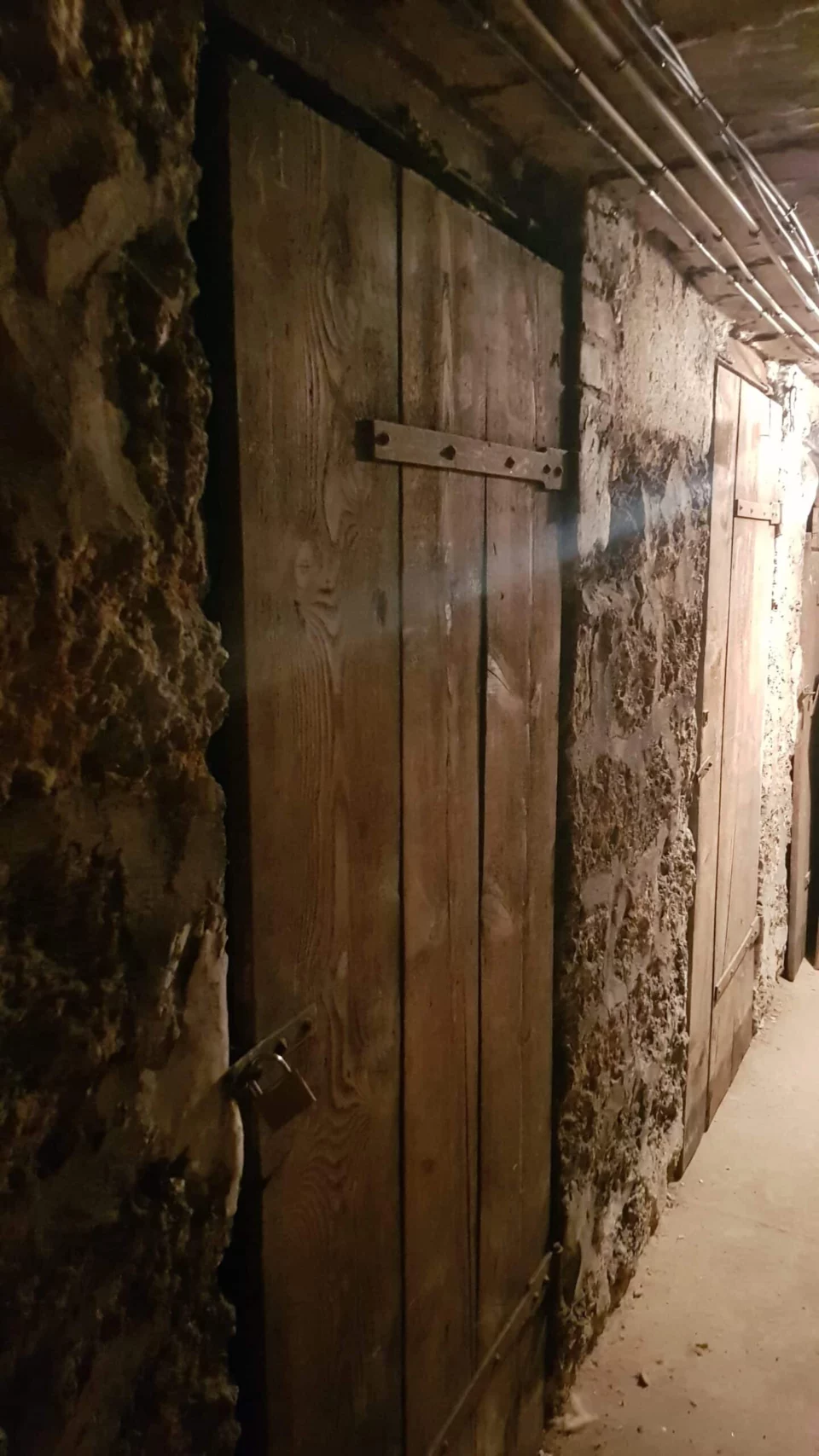 Porte de bois et mur de pierre d’une cave d’immeuble parisien
