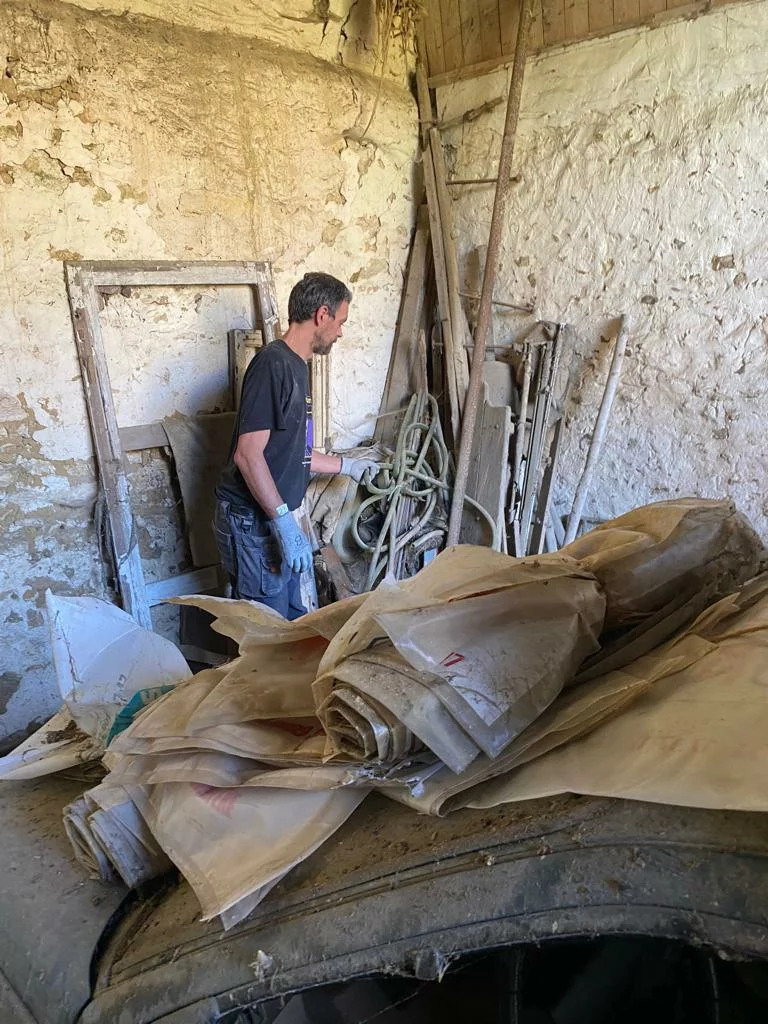 Sacs de gravats et objets sortis d’une cave voûtée